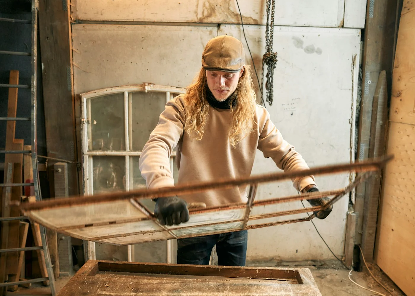 Un artisan restaure une fenêtre ancienne dans son atelier